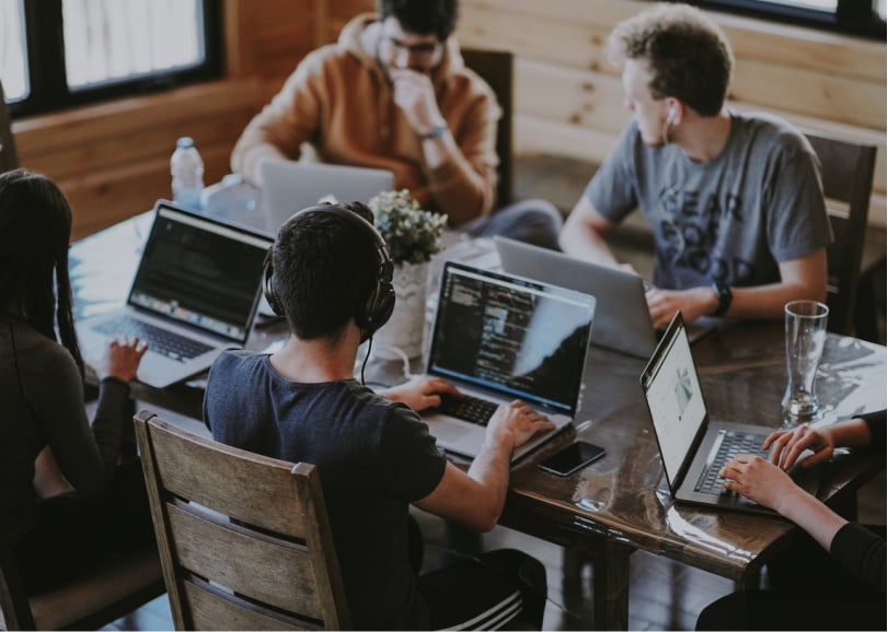 People working on laptops around a table