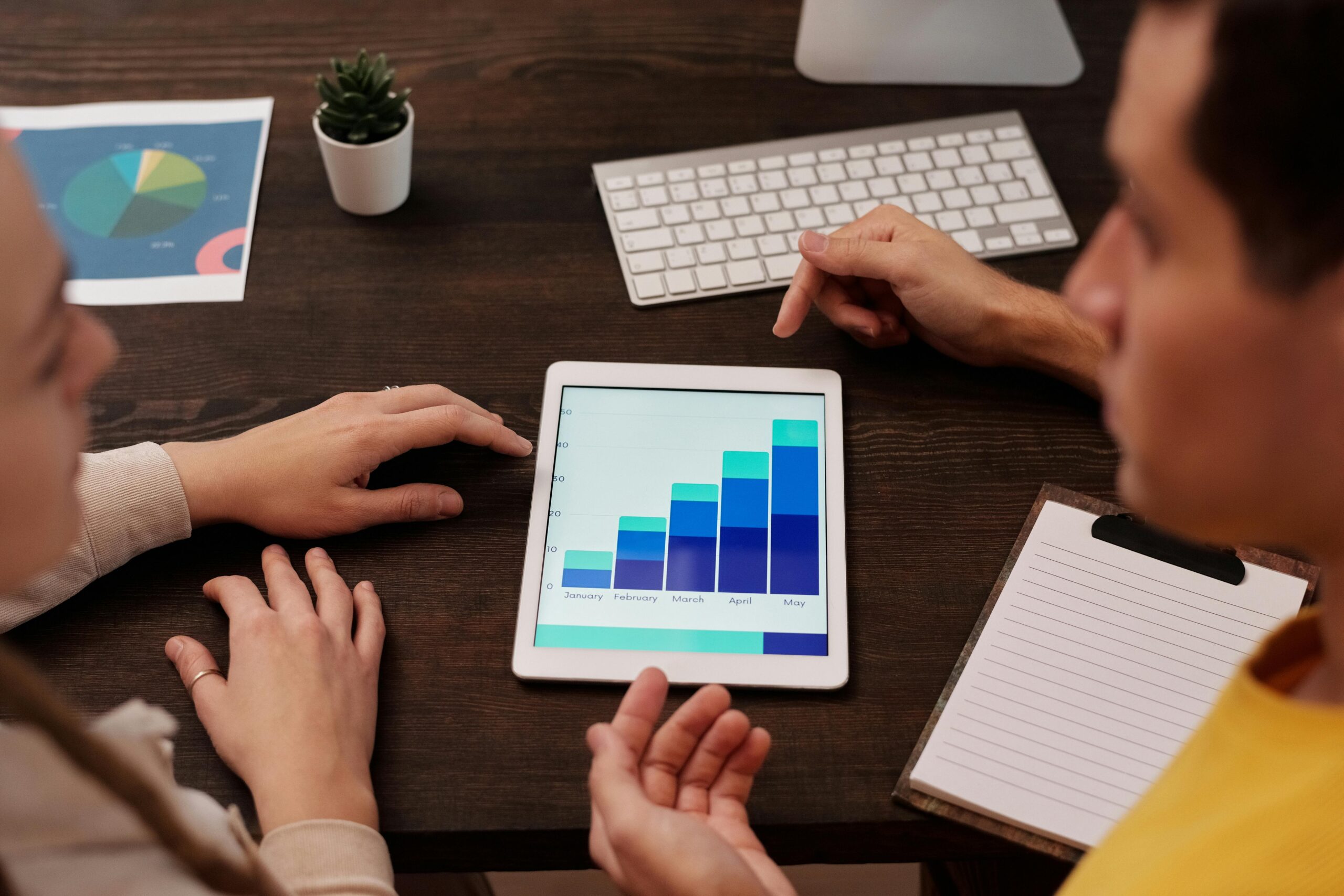 A man and woman looking at data on a tablet