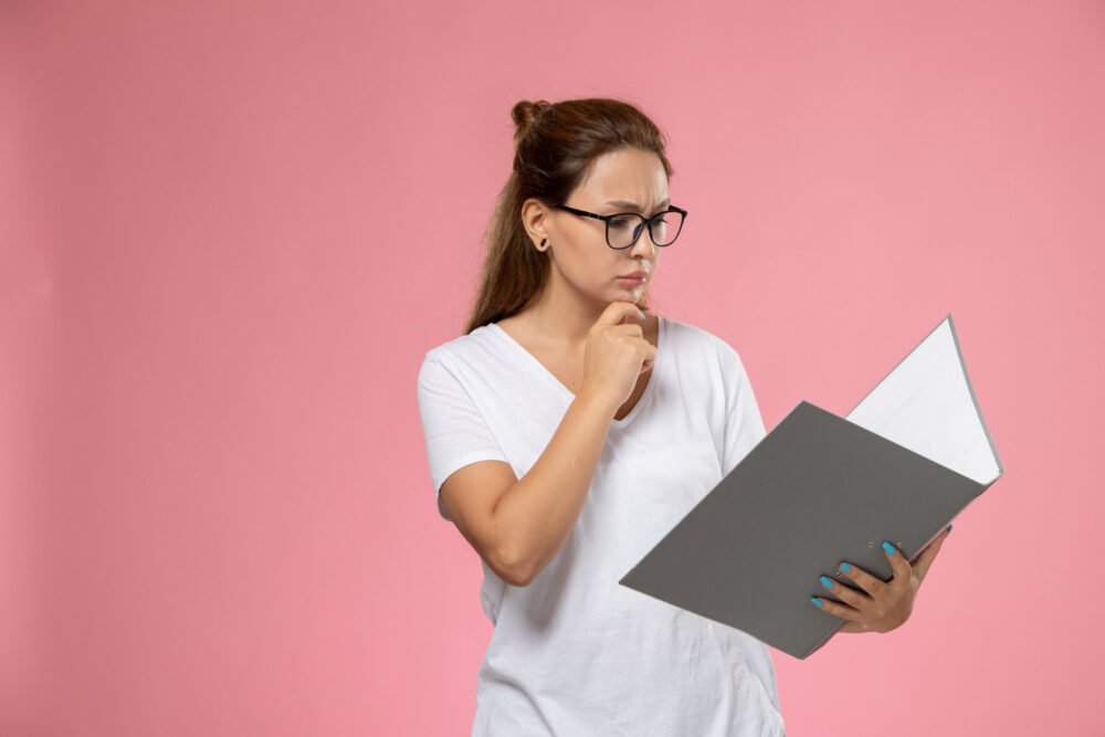 woman holding and reading a folder looking inquisitive
